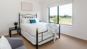 a bedroom with a bed and a large window at Holiday of Perfect Strokes in Cape Schanck