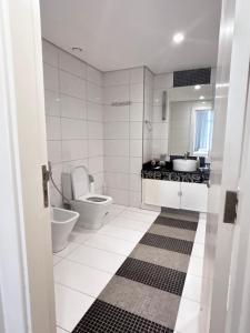 a white bathroom with a toilet and a sink at برج داماك جده شقه مطله على البحر damac jeddah in Jeddah