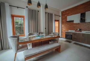 a kitchen with a table and chairs and a brick wall at Moana La Vie - Polhena in Matara