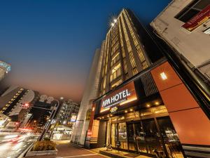 a building with a sign on it on a city street at APA Hotel Nambaminami Daikokucho Ekimae in Osaka