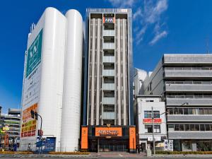 a tall white building in a city at APA Hotel Nambaminami Daikokucho Ekimae in Osaka