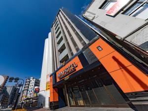 an orange building with a macyeyes sign on a street at APA Hotel Nambaminami Daikokucho Ekimae in Osaka