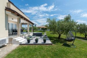 a backyard with a patio with a table and chairs at Vista OLIVO in Brtonigla
