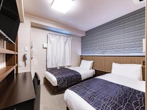 a hotel room with two beds and a flat screen tv at APA Hotel Nambaminami Daikokucho Ekimae in Osaka