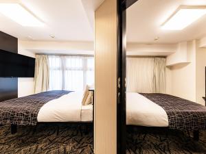 a hotel room with two beds and a window at APA Hotel Nambaminami Daikokucho Ekimae in Osaka