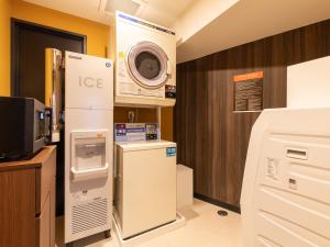a kitchen with a refrigerator and a microwave at APA Hotel Nambaminami Daikokucho Ekimae in Osaka