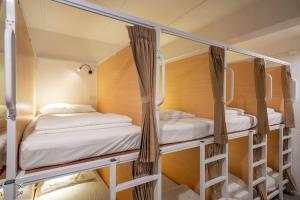 a room with three bunk beds in it at Kuha Phuket Old Town in Phuket Town