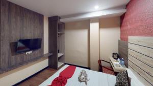 une chambre d'hôtel avec un lit et une télévision à écran plat dans l'établissement Paragon Nagoya Hotel Batam, à Jodoh