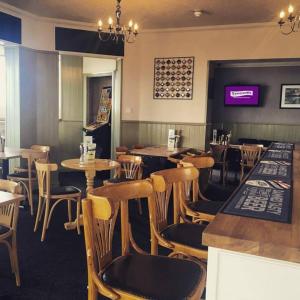 a restaurant with tables and chairs and a bar at Harrow Lodge Hotel in Shanklin