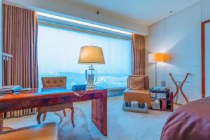 - une chambre avec un bureau et une grande fenêtre dans l'établissement Hotel Leader Changsha, à Changsha