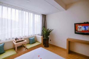 a living room with a tv and a table at Super 8 Hotel Xiamen Train Station Holiday Mall Branch in Xiamen