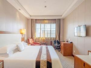 a hotel room with a large bed and a desk at Huzhou Zhebei Hotel in Huzhou +193 photos