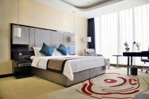 瀋陽市にあるPacific Regency Hotel Shenyangのベッドルーム(大型ベッド1台、グランドピアノ付)