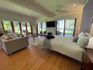 a bedroom with a large bed and a couch at Lake House Escape - Lake Front Couples Retreat! in Morisset East