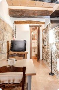 a living room with a table and a tv in a room at IL NIDO di PITIGLIANO in Pitigliano