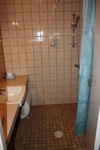 La salle de bains est pourvue d'une douche, d'un lavabo et de toilettes. dans l'établissement Jokirannan Majoitus, à Kokemäki