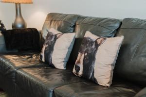 a brown leather couch with two pillows on it at A Beary Good Getaway condo in Pigeon Forge +62 photos