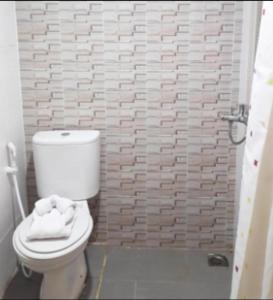 Un baño con un inodoro blanco y una pared de ladrillo. en Karimun City Hotel, en Tanjung Balai Karimun 30 fotos más