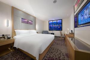 a hotel room with a large bed and a tv at Lavande Hotel Guangzhou Shangxiajiu Pedestrian Street Hualin Temple Metro Station in Guangzhou