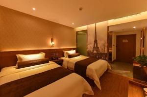 two beds in a hotel room with a view of the eiffel tower at James Joyce Coffetel Baoding Gaobeidian Railway Station Branch in Gaobeidian Zhan