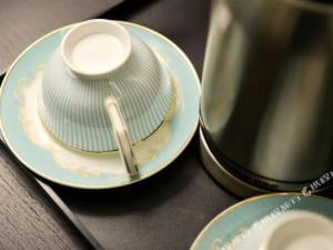 ein Stapel Teller mit einer Kaffeetasse oben drauf in der Unterkunft Xana Hotelle Nanchang Honggutan in Nanchang