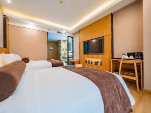 pokój hotelowy z dwoma łóżkami i telewizorem w obiekcie James Joyce Coffetel Xi'an Laochenggen Hongmiaopo Metro Station w mieście Xi'an