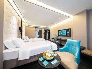 ein Hotelzimmer mit großem Bett und Schreibtisch in der Unterkunft Xana Hotelle Nanchang Honggutan in Nanchang