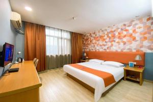 une chambre avec un lit et un bureau avec un ordinateur dans l'établissement Pai Hotel Kunshan Youyi Hospital Qingyang South Road Branch, à Lujiabangzhan