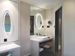 a bathroom with two sinks and a mirror at Xana Lite Shenyang Beiling Park Liaoning Building Branch in Shenyang +241 photos