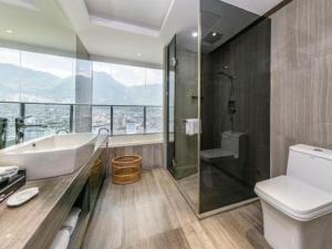 Un baño con bañera, inodoro y ducha. en Fortune Hotel Ningde, en Ningde