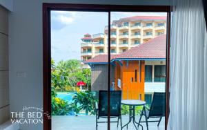 a view of a hotel with a table and a balcony at The Bed Vacation Rajamangala Hotel in Songkhla