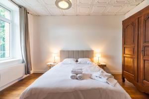 a bedroom with a bed with two towels on it at Hôtel Lefort - L'Oasis Urbaine in Guingamp