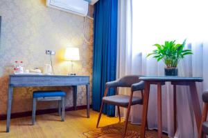 ein Raum mit einem Tisch und zwei Stühlen und einem Fenster in der Unterkunft PAI Hotel·Luoyang Dingding Bei Road Hongjin Logistics International Peony Garden in Luoyang