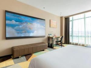 a bedroom with a large screen on the wall at Chonpines Hotel Guangzhou Sunac Cultural and Tourism City Shiling in Huadu