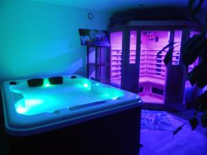 a room with a jacuzzi tub with purple lights at Les Roulottes des Bois d'Ormes in Bessey-en-Chaume
