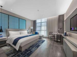 a large bedroom with a large bed and a television at Echarm Hotel Huaihua Vocational College in Huaihua +170 photos