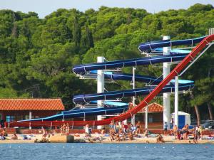 a group of people on a beach with a water slide at Apartments Angie in Biograd na Moru