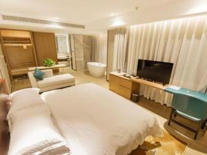 a hotel room with a large bed and a television at Borrman Hotel Liuzhou Guizhong Avenue Liugao in Liuzhou