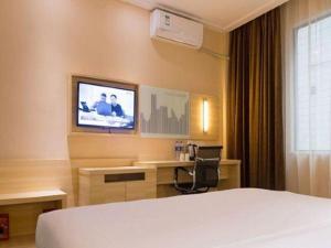 a hotel room with a bed and a television at City Comfort Inn Guangzhou Zengcheng Yonghe Yongkang Road in Guangzhou