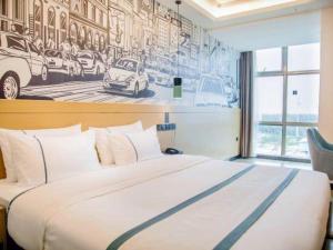 万寧市にあるCity Comfort Inn Wanning Wan'An Avenue High Speed Railway Stationの壁に絵が飾られた大きなベッドのある寝室 +139枚の写真