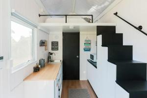 una piccola cucina con scala nera in una casetta di Little Magic Tiny House by Tiny Away a Coolangatta