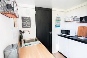 una cucina con lavandino e porta nera di Little Magic Tiny House by Tiny Away a Coolangatta