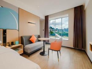 une chambre d'hôtel avec un lit, un canapé et une table dans l'établissement City Comfort Inn Hechi Yizhou Erqiao, à Qingyuan 277 autres photos