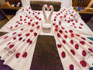 two wedding gowns covered in red hearts with a couple of swans at James Joyce Coffetel Changchun People's Square in Changchun
