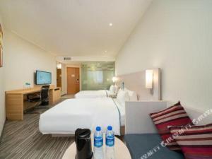 a hotel room with a large bed and a desk at City Comfort Inn Nanning Minzhu Road Guangxi Dianwang in Nanning +111 photos