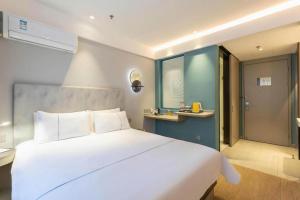 a bedroom with a large white bed in a room at Magnotel Hotel Suzhou Wanda Plaza Huaihai Road in Suzhou +179 photos