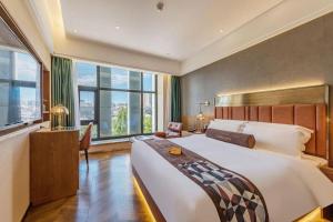 sypialnia z dużym łóżkiem i dużymi oknami w obiekcie James Joyce Coffetel Tianjing First Central Hospital Nankai University w mieście Tiencin +290 zdjęć
