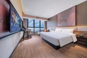 a hotel room with a large bed and a flat screen tv at IU Hotel Chongqing Airport T3 Terminal in Chongqing +256 photos