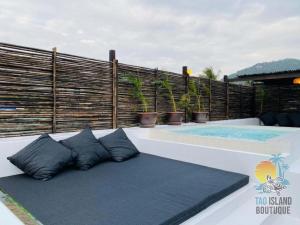 a bench with pillows next to a swimming pool at Tao Island Boutique Hotel in Koh Tao