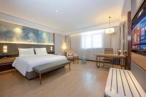 a hotel room with a large bed and a tv at Green Tree Inn Xuzhou Tongshan Wanda Plaza Yuquanhe Metro Station in Xuzhou